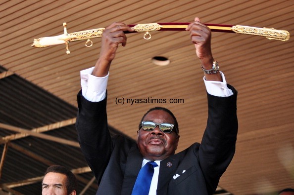 Newly elected Malawian President Arthur Peter Mutharika (C) holds up the Sword of Command bestowed to him by Malawi's Defence Force Commander