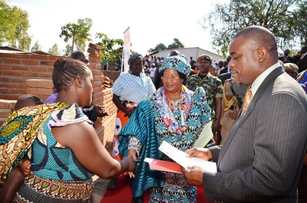 President Banda greets a beneficiary of a new house being constructed under the Mudzi Transformation Trust