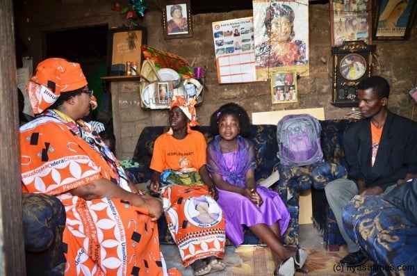 President Banda inside the hut interacting with Nyaude, the husband and Rita