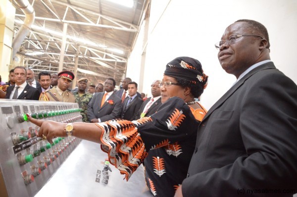 President Banda turns on one of the machines in the factory
