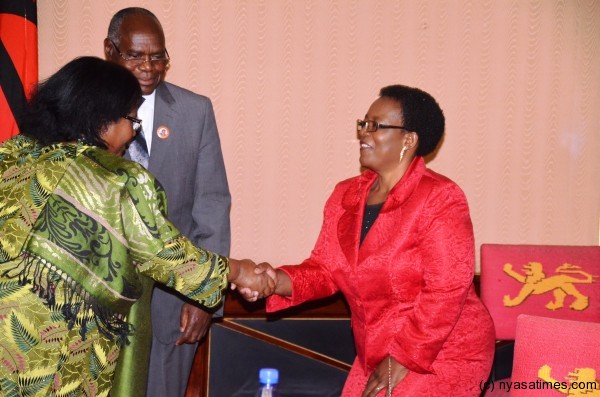 President Joyce Banda congratulates Dr. Munthali's wife after the husband, looking on, took oath of office as cabinet minister
