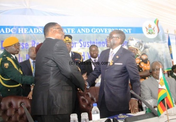President Mutharika and Mugabe shaking hands after handover of SADC chairmanship  in Zimbabwe - Pic by Stanley Makuti, Mana