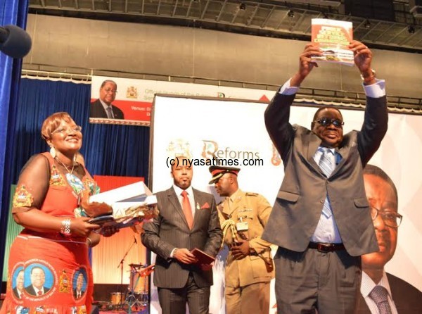 President Mutharika shows the reforms report submitted by the commissioners . - Pic by Stanley Makuti