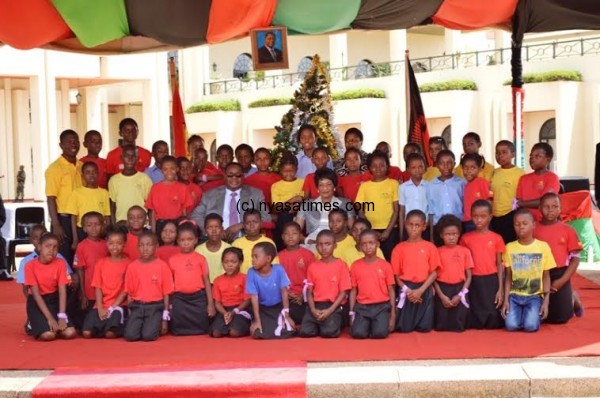 President Peter Mutharika and first lady Gertrude Mutharika pose with children during a christmas party at Kamuzu Palace