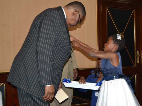President Peter Mutharika, being sticked a flag on the jacket by a young girl for MACOHA Inauguration of Flag Week at Kamuzu Palace-(c) Abel Ikiloni, Mana