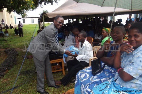 Principal secretary for the ministry of Health Dr.Charles Mwansambo giving symbolic present to Clement Chanza one of the petients at Kamuzau Central Hospital.pic by Mirriam Kaliza