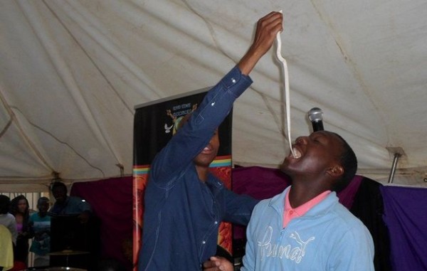 Prophet Penuel Mnguni orders a member of his congregation to eat a live snake