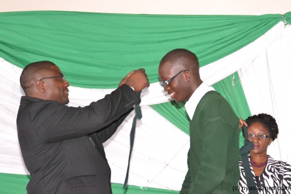 Roy Kachale Banda presents a medal to one of the students