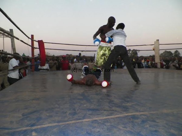 Ref Jobson Adams restrains Chipembere as Mwamaso lays flat on the canvas.