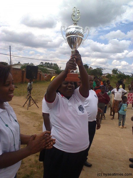 Regional Sports Officer for the North,Gergina Msowoya hoists the NICO Life Netball Trophy.