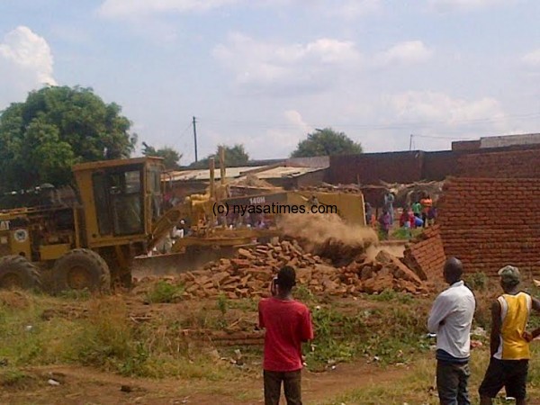 Residents of Area 22b watch helplessly as their shops are being demolished.