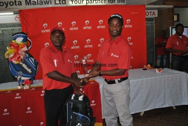 Runner-up Victor Kachepatsonga receives his prize from Airtel