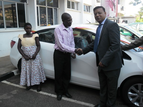 Mshanga (pink shirt)  flanked by wife recieving car keys  from Airtel Marketing Director Tanmoiy Saha