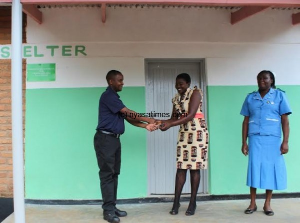 Mwamadi presenting keys to Aida as District Nursing Officer Ngwalo-Banda looks on