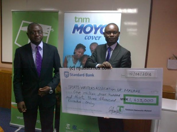 SWAM officials displaying a dummy cheque from TNM