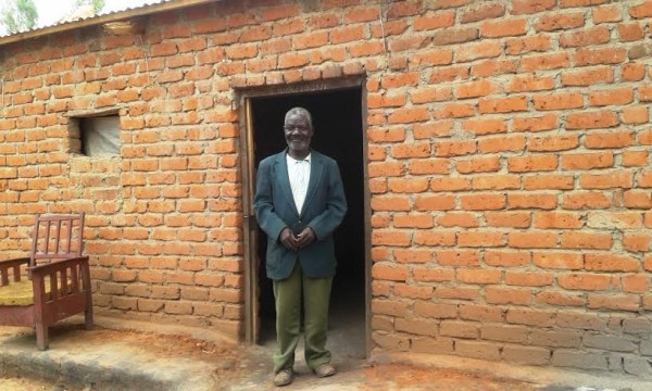 Solomoni standing outside his house in TA Mkanda which near completion.