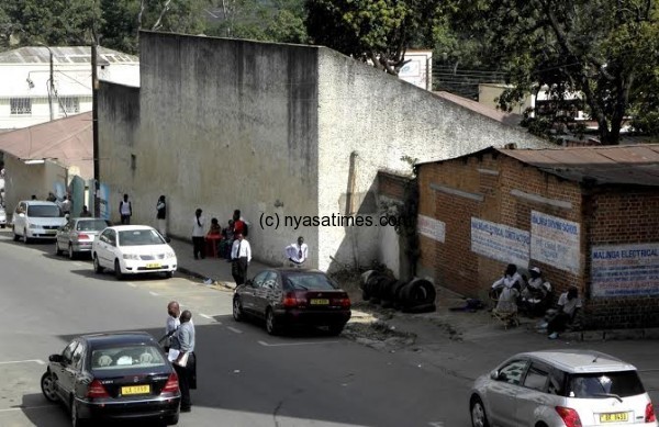 Stewert Street in Blantyre CBD, one of several streets that host scores of idling men as seen (right) the men sitting on chairs- Pic Lucky Mkandawire 
