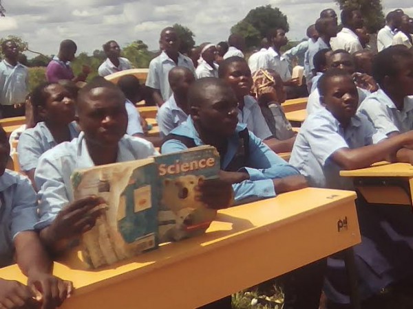 Students sitting on desks donated by PIL