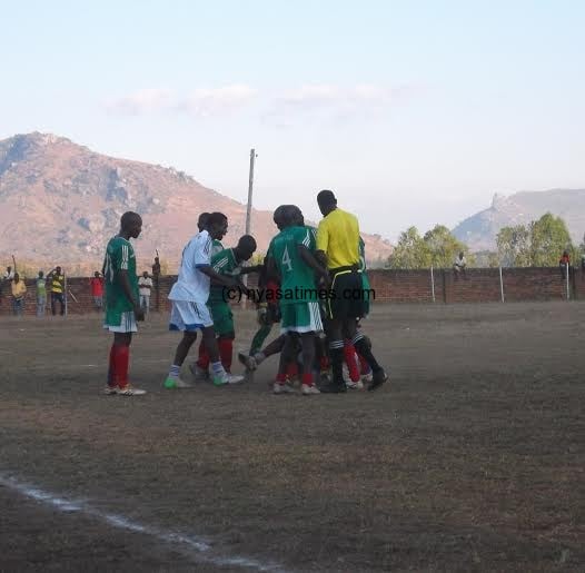 Support Battalion players (in green) trying to lift Luhanga on the ground.