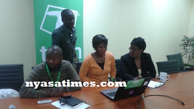 Journalist Emmanuel Chibwana (standing) draws the MK100,000 winner witnessed by Nsapato (left) and Mirriam Kumbuyo (right) of Lotteries Board and TNM's Sungeni Madeira