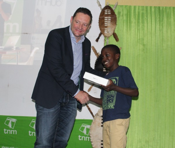 TNM's CEO Douglas Stevenson presenting an apple to smart kid winner Panache Jere