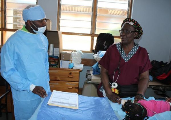 TNM's Limbani Nsapato (L) being briefed how operation is done in the theatre by Kenyan based doctor (R)