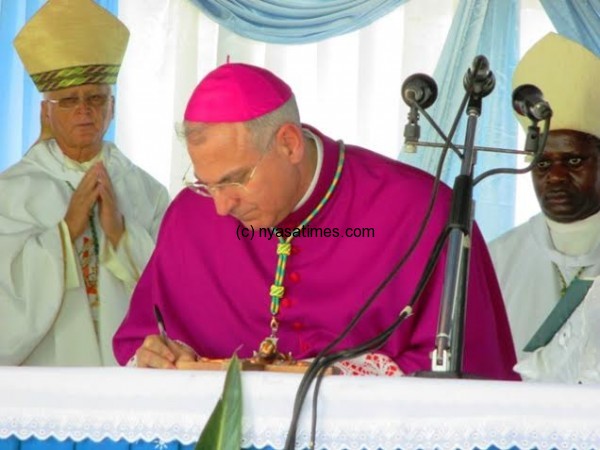The Apostolic Nuncio to Malawi and Zambia Archbishop Julio Murat signing the endorsment signature to accept the new Archbishop....Photo Jeromy Kadewere.