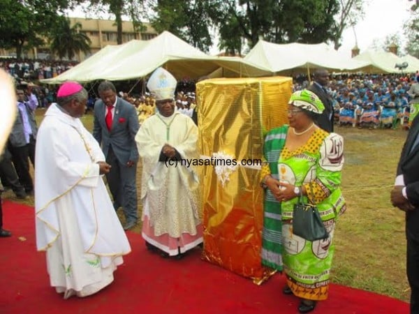 The President donating her gift to the new Archbishop...Photo Jeromy Kadewere