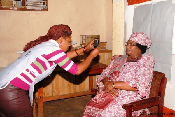 The President pose for a photograph when she registered as a voter in the 2014 tripartite elections