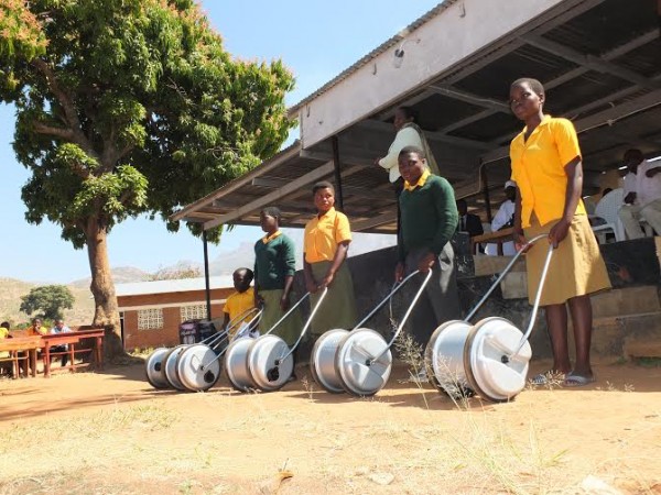 The beneficiaries display their water barrels