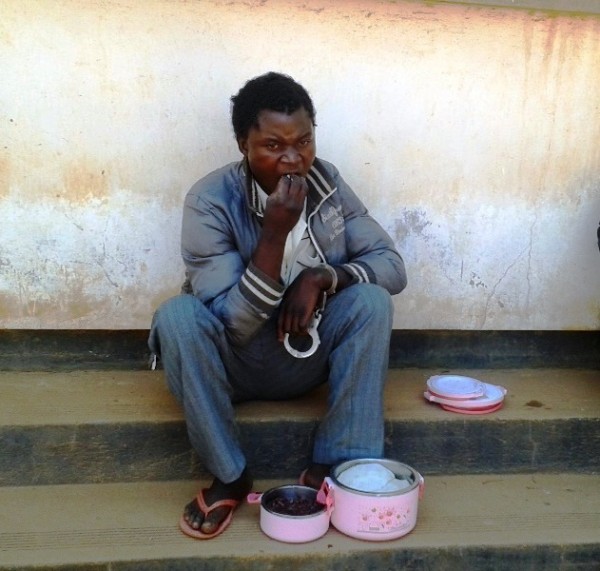 The convict Yasin eating nsima outside before appearing  before the court pic sarah munthali mana