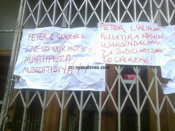 The protesters hang posters at the High Court in Zomba.