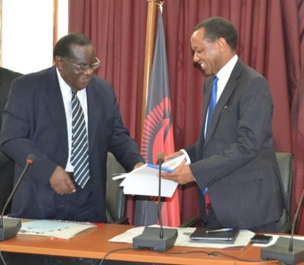 Time to smile the Malawi Savings Bank is all yours now, Finance Minister Goodall Gondwe hands over documents to Thom Mpinganjira of FDH