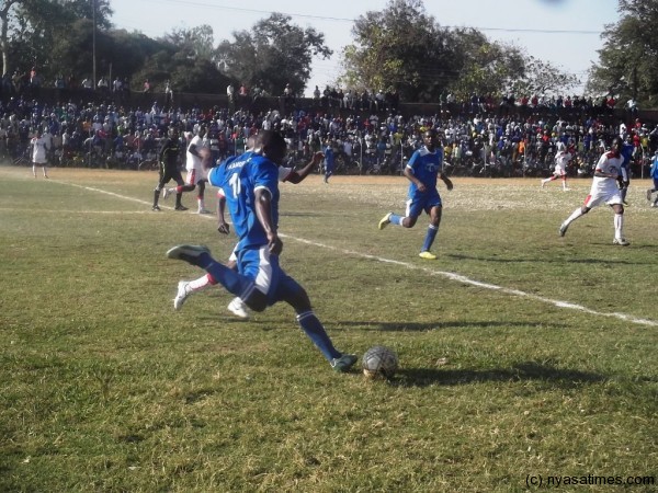 Timothy Chitedze callenged by a Red Lions player. Photo by Elijah Phimbi, Nyasa times