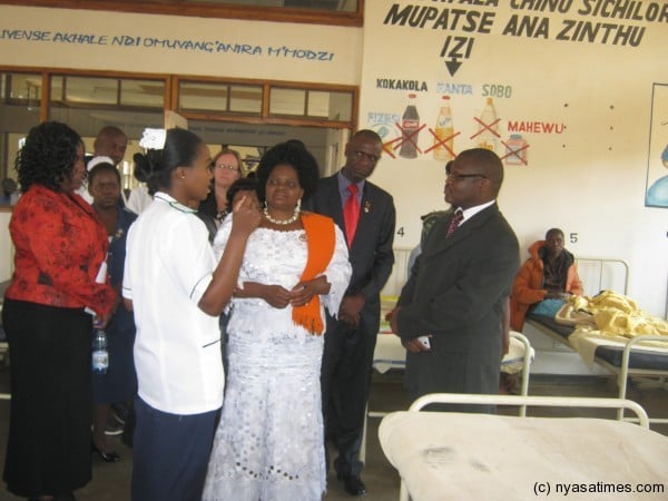 Touring the hospital ... medical worker briefs the minister on the hopistal operations