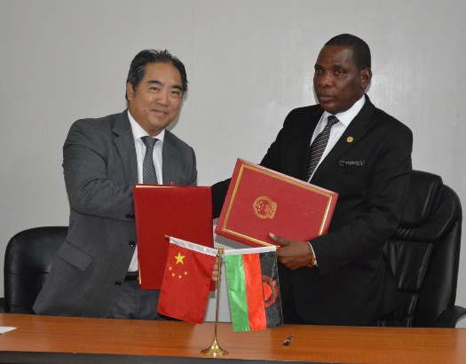 Trade and Industry MinisterJoseph Mwanamvekha exchanging signed documents with the Chinese Ambassador to MalawiH.E.Mr.Zhang Qingyang - Pic by Stanley Makuti