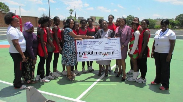 Tsilizani presents a cheque to the Malawi Queens.-Photo by Jeromy Kadewere