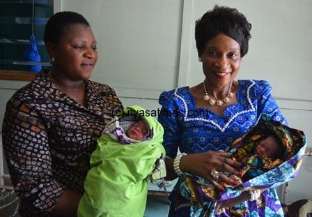 The First Lady and a mother carries hold twins (boy and girl) born on Christmas day 