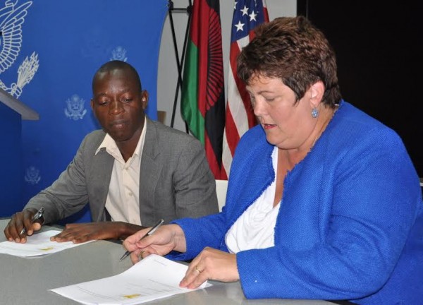 US Ambassador Virginia Palmer and a ben ... nity representative signing a grant