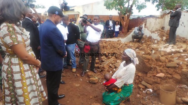 VP Chilima with a rainstorm victim who was made homeless after her house was destoryed at Kauma in Lilongwe