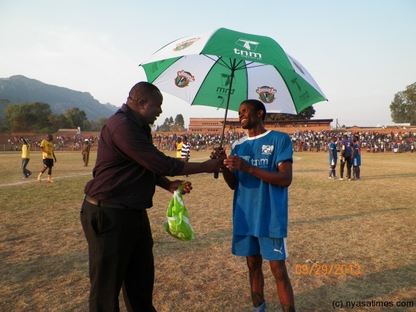 Wanderers' Timothy Chitedze gets man of the match award from Sulom's Charles Manyungwa, Pic Leonard Sharra, Nyasa Times