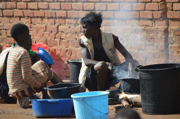 Woman preparing food outside Illumination Church where victims are living at Masasa (C)Stanley Makuti