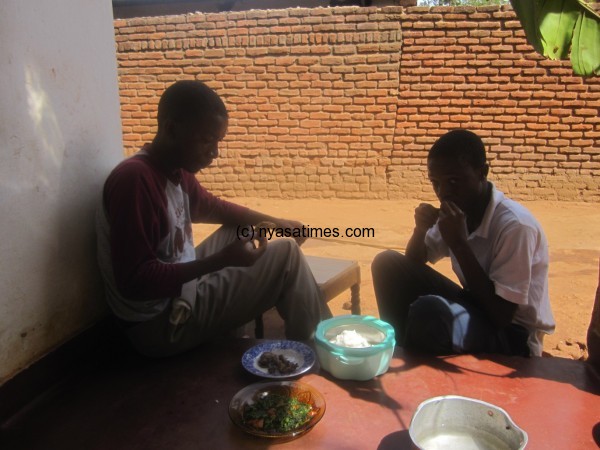 Zack and his brother enjoying nsima cooked by his invention