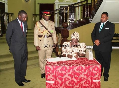 Zambian envoy signs a visitors book at Kamuzu Palace