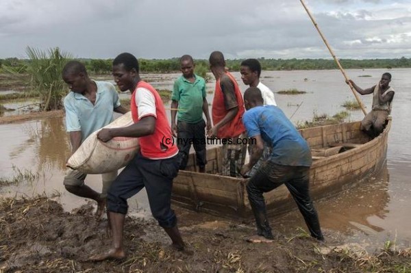 A rescue team unloads goods from a canoe as it arrives in Chambuluka village on the banks of the flooded Ruo river in Malawi's southern Nsanje district on January 18, 2015- ©Amos Gumulira (AFP)