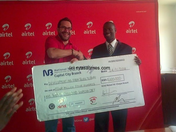 Enock Juma and Heiko holding a dummy cheque.