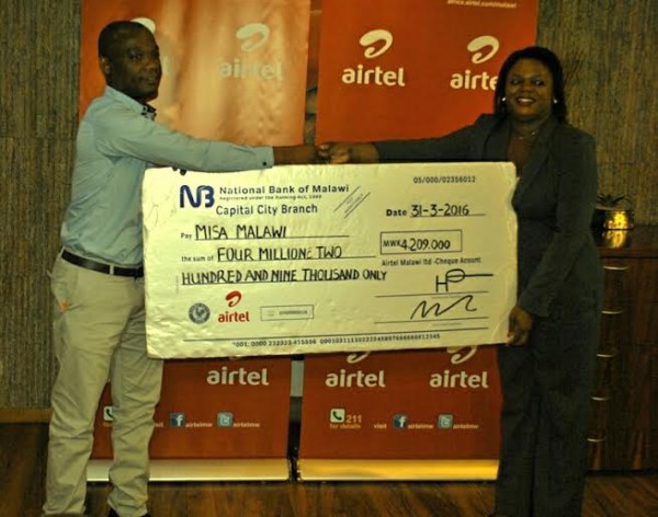  Airtel's Managing Director Charles Kamoto officially hands over the cheque to MISA's Board Treasurer Wezi Ngoma