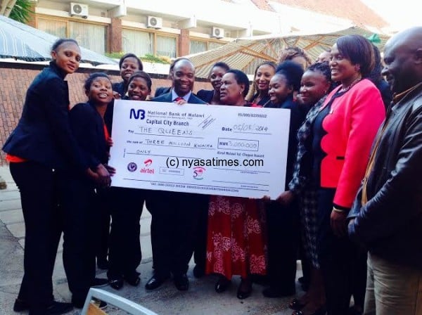 Malawi Queens receiving the MK3 million cheque From Airtel