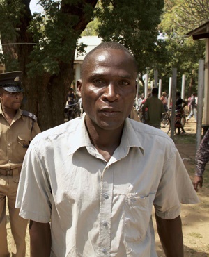 Eric Aniva (R), known as a "hyena," arrives to the Magistrate Court n Nsanje.-AFP PHOTO / ELDSON CHAGARA