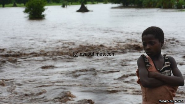 A boy stands whose family home was washed away by floods.-Photo by Thoko Chikondi , BBC